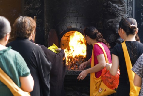 CHINA, Zhejiang , Putuoshan, Puji Temple outer courtyard. Burning incense packaging material and