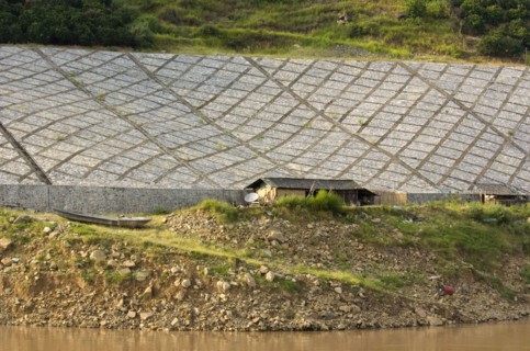 CHINA, Chongqing , Yangtze, Stone lining the Yangtze River embankment near Wushan with satellite TV