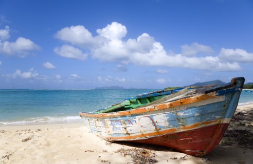 WEST INDIES, Grenada, Carriacou, Waves breaking on Paradise Beach at L'Esterre Bay with an old