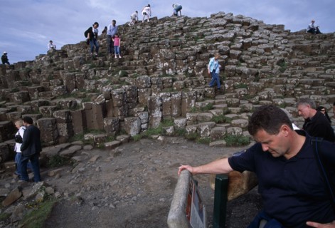 NORTHERN IRELAND, County Antrim, Giants Causeway, Visitors walking over the interlocking basalt