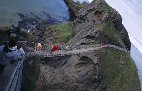 NORTHERN IRELAND, County Antrim, Ballintoy, Carrick-a-Rede Rope Bridge. Vistors walking over rope