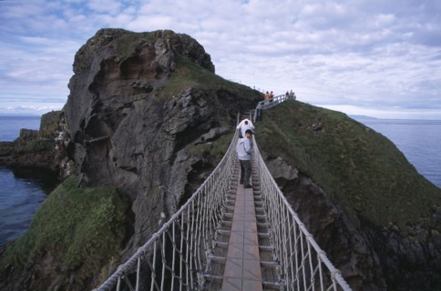 NORTHERN IRELAND, County Antrim, Ballintoy, Carrick-a-Rede Rope Bridge. Vistors walking over rope
