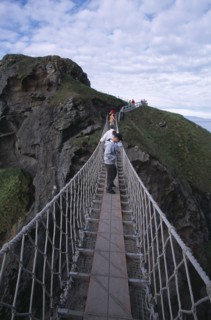 NORTHERN IRELAND, County Antrim, Ballintoy, Carrick-a-Rede Rope Bridge. Vistors walking over rope