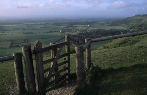 ENGLAND, West Sussex, Devils Dyke, Stile gate on Devil’s Dyke with view over lush green South Downs