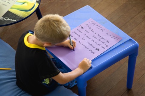 RELIGION, Festivals, Christmas, Young left handed boy at Christmas Eve sitting down and writing his
