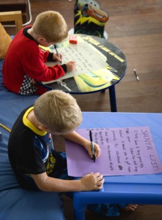 RELIGION, Festivals, Christmas, Two young left handed boys on Christmas Eve sitting down and