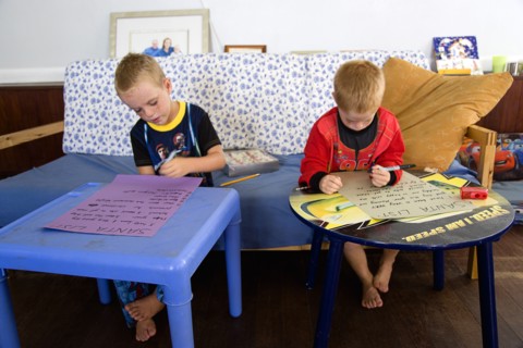 RELIGION, Festivals, Christmas, Two young left handed boys on Christmas Eve sitting down on a sofa