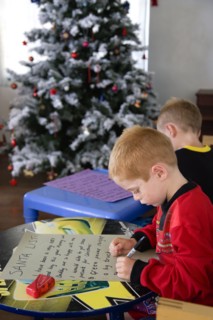 RELIGION, Festivals, Christmas, Two young left handed boys on Christmas Eve sitting down on a sofa