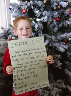 RELIGION, Festivals, Christmas, Young smiling red headed boy standing in front of a decorated