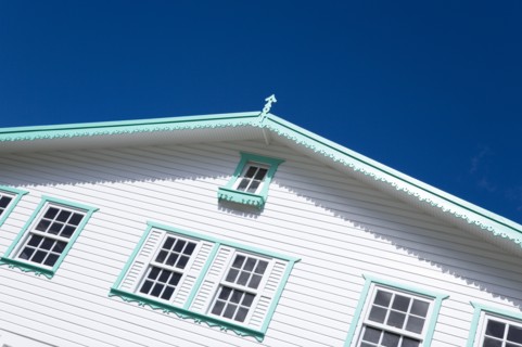 WEST INDIES, Grenada, Carriacou, White timber clapperboard front of a house with turquoise green