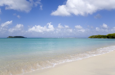 WEST INDIES, Grenada, Carriacou, The calm clear blue water breaking on Paradise Beach in L'Esterre