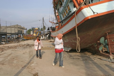 THAILAND, Phang Nga District, Nam Khem, "Tsunami. People walk past boats that have been pushed onto