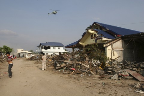 THAILAND, Phang Nga District, Nam Khem, "Tsunami. Locals look up at a helicopter which is surveying