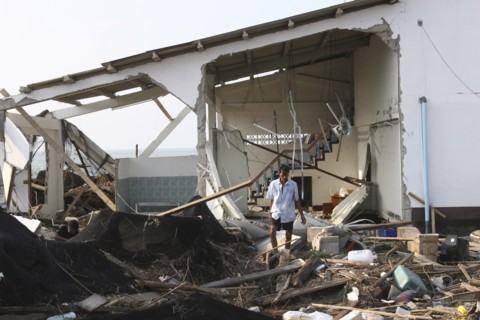 THAILAND, Phang Nga District, Nam Khem, "Tsunami. A man stands outside of what is left of his house