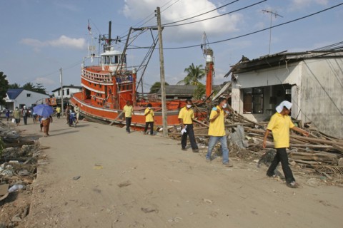 THAILAND, Phang Nga District, Nam Kem, "Tsunami. Volunteers and the locals walk past a fishing boat