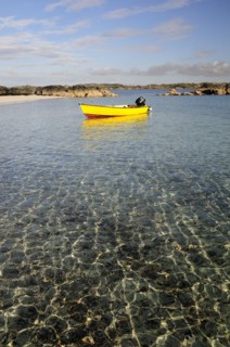 SCOTLAND, Argyll, Isle Of Mull, Yellow boat anchored in clear waters wide angle