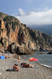 FRANCE, Corsica, Golfe Di Porto, "Plage De Bussaglia, sandy beach with sunbathers & umbrellas.