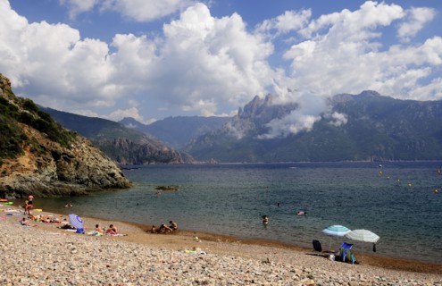 FRANCE, Corsica, Golfe Di Porto, "Plage De Bussaglia, shingle beach with umbrellas & bathers & Capo