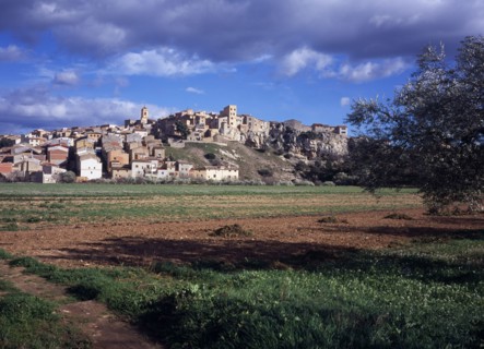 SPAIN, Catalonia, Tarragona, El Pinell de Brai. Hilltop village seen from a field below.
