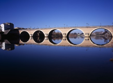 FRANCE, Dordogne, Perigeux, Bergerac. Old bridge over River Dordogne with its reflection on the