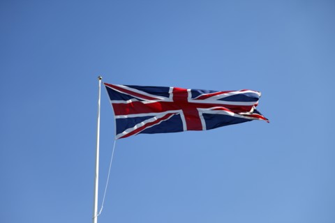 CLIMATE, Wind, Flags, British Union Jack flag flying in wind against blue sky.