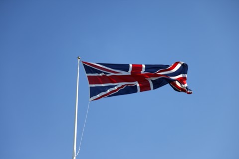 CLIMATE, Wind, Flags, British Union Jack flag flying in wind against blue sky.