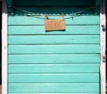 WEST INDIES, Grenada, Carriacou, New Arrival sign on the padlocked turqoise shutter of a shop in