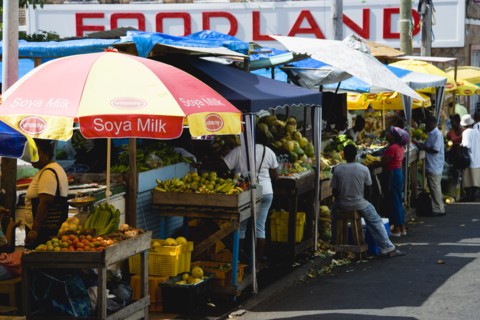 WEST INDIES, Grenada, St Georges, Busy fruit and vegetable stalls under umbrellas in Market Square