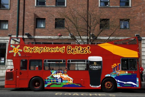 IRELAND, North, Belfast, "College Avenue, Red open top double deck tour bus outside Jurys hotel."