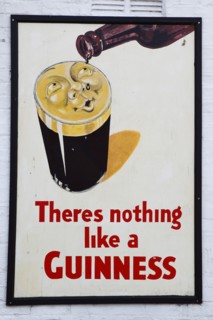 IRELAND, North, Belfast, "Bank Square, Old metal Guinness sign decorating the exterior Kelly's