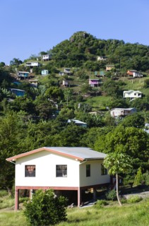 WEST INDIES, Grenada, St George, Houses built on stilts lining a hillside.