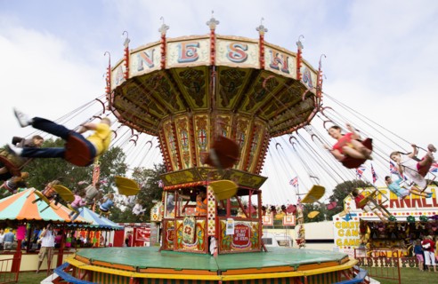 ENGLAND, West Sussex, Findon, Findon village Sheep Fair Children in motion riding on a swing