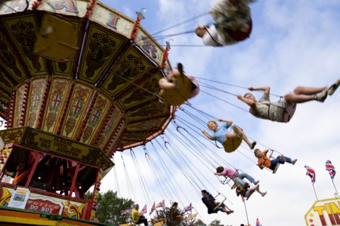 ENGLAND, West Sussex, Findon, Findon village Sheep Fair Children in motion riding on a swing