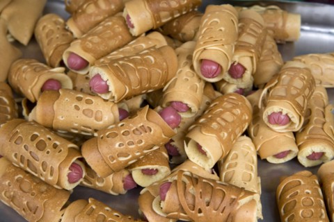 THAILAND, North, Chiang Mai, Close of small sausages wrapped in pancakes on sale in market. Pigs in