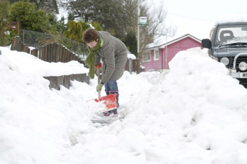 WEATHER, Winter, Snow, Snow scenes in Perth Scotland woman clearing snow from pathway with shovel