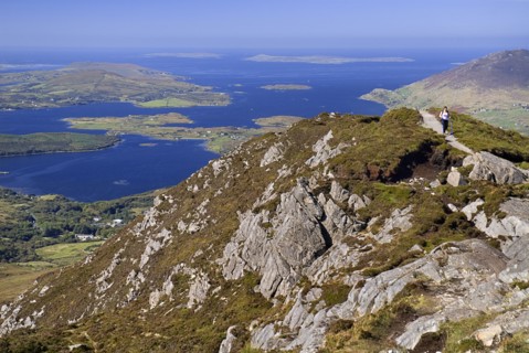 IRELAND, County Galway, Connemara, Diamond Hill, A hiker approaches the summit with Ballynakill