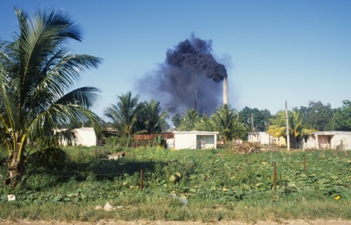 Cuba, Varadero, Sugar cane factory emitting clouds of black smoke from chimneys.