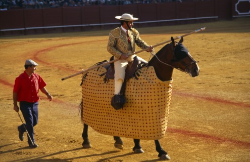 Spain, Andalucia, Seville, Picador with lance riding a padded and blindfolded horse in the bullring