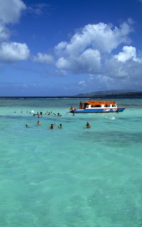 West Indies, Caribbean, Tobago, Tourists swimming in the shallow water beside a glass bottomed boat