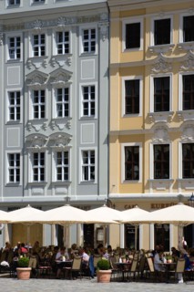GERMANY, Saxony, Dresden, People sitting at restaurant cafe tables under umbrellas in Neumarkt