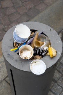 GERMANY, Saxony, Dresden, Street litter bin on pavement sidewalk full of rubbish.