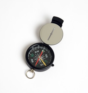Travel, Navigation, Map Reading, Sighting compass with dial pointing to magnetic north on a white
