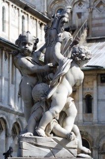 ITALY, Tuscany, Pisa, A statue of three Cherubs in front of the Duomo Cathedral in The Campo dei