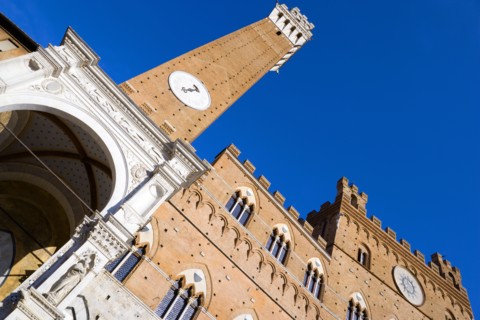 ITALY, Tuscany, Siena, Religious carvings on the portico entrance below the Torre del mangia