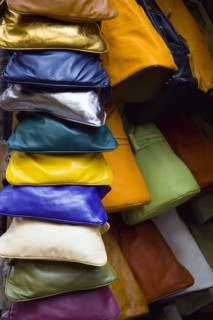 ITALY, Tuscany, San Gimignano, Colourful locally made leather bags displayed in a shop doorway.