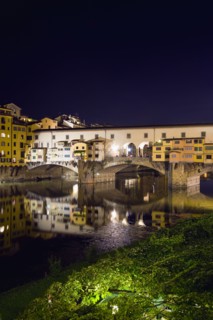 ITALY, Tuscany, Florence, Ponte Vecchio medieval bridge across River Arno illuminated at night with