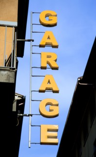 ITALY, Tuscany, Florence, Sign in yellow letters attached to building and hanging over street for a
