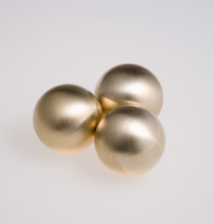 Industry, Machinery, Components, Three brass metal lathe turned ball bearings on a white background