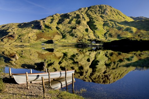 IRELAND, County Galway, Connemara, Kylemore Lough with moored rowing boat and Benbaun Mountain