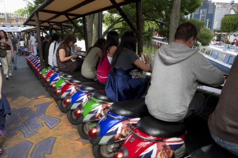 ENGLAND, London, Camden Town, People sitting on small colorful vespa scooters on a line formation